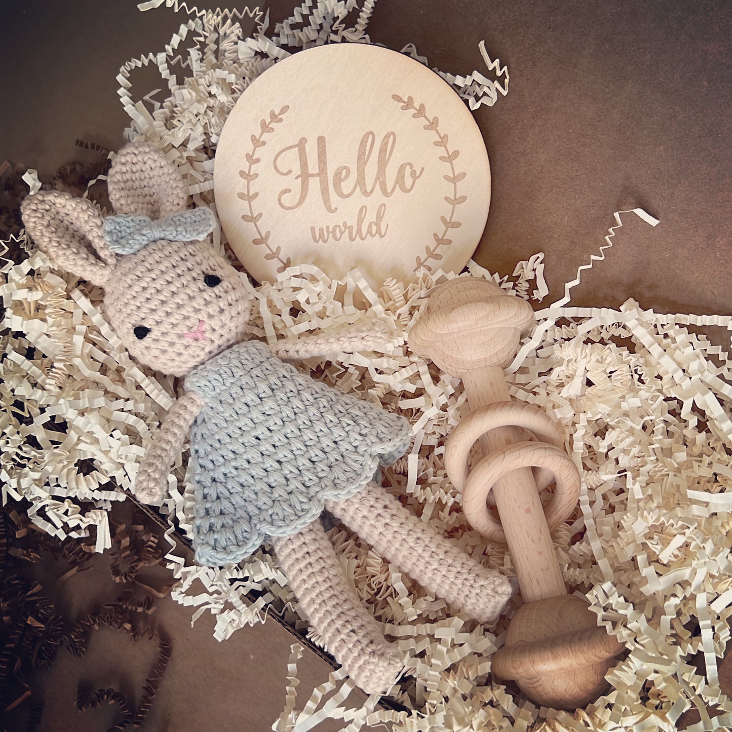 Baby Shower gift box that includes Crochet handmade bunny doll dressed in a crochet blue dress and a matching blue crochet bow, made with organic cotton yarn this cute box also includes a beechwood baby toy.This cute crochet toy bunny bundle is the cutest baby shower gift a newborn could keep for years